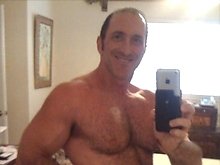 Big muscled dude lifts weight and shows his hairy chest